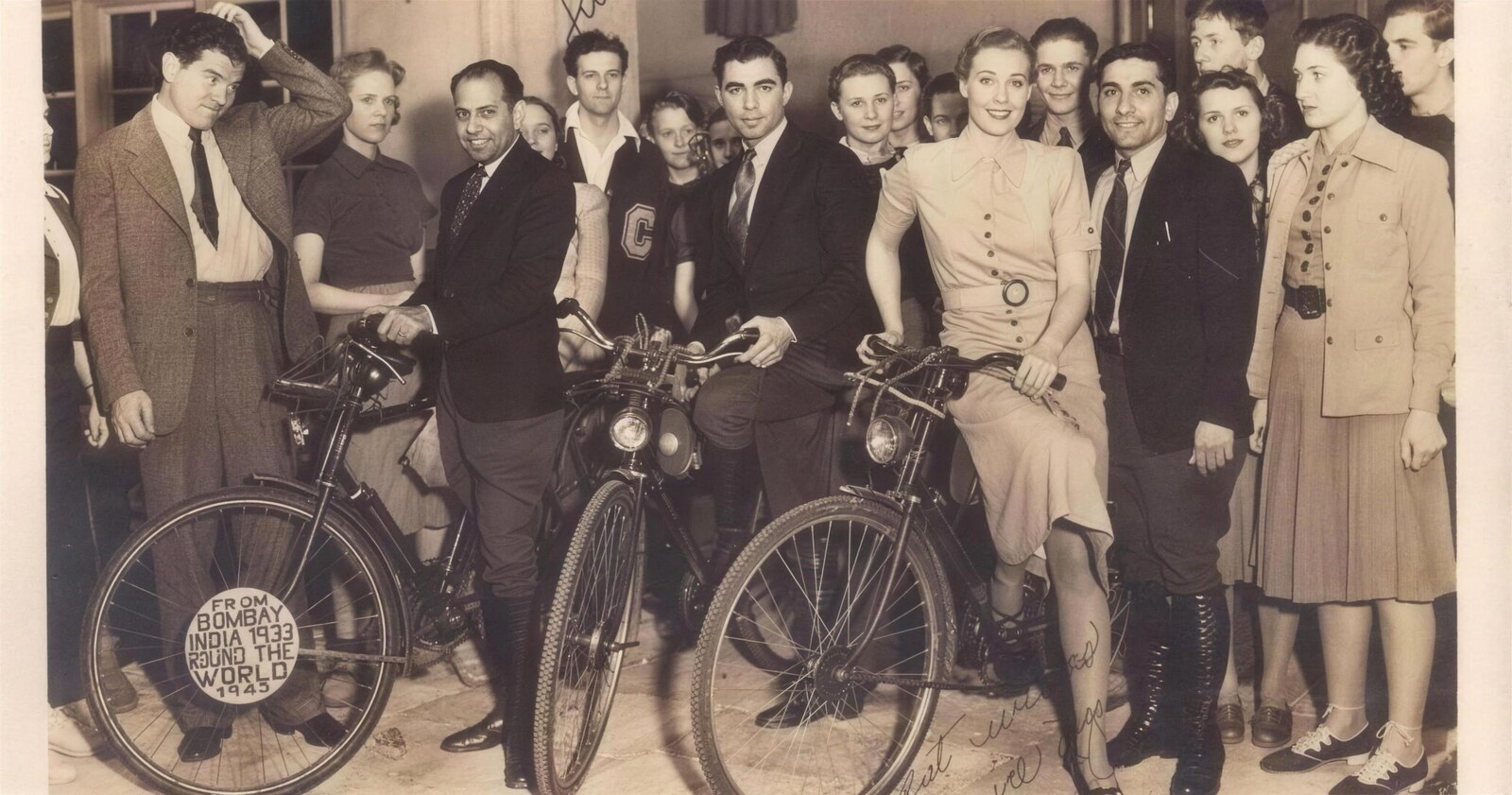 The cyclists at a crowded reception abroad, surrounded by well-wishers